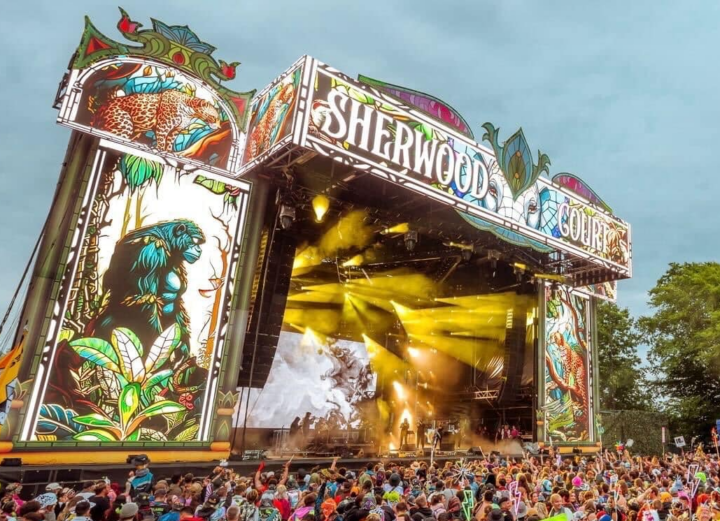 Photo of a colorful stage and full crowd in front of it at Electric Forest