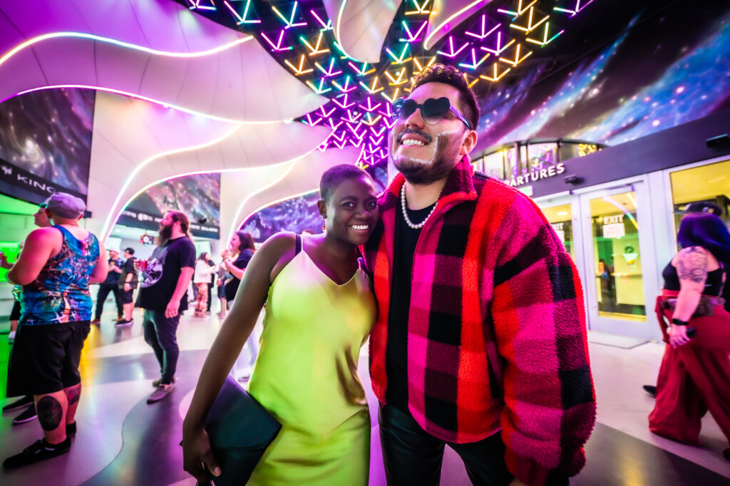 Photo of a black woman in a green dress and a man in a black and red flannel.