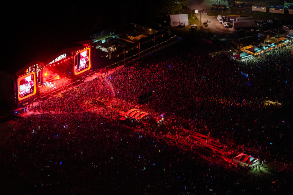 Crowd of a festival at night, illuminated in red.