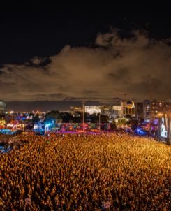 III Points Miami Music Festival: large crowd facing mainstage with glowing orange lights.