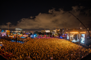 III Points Miami Music Festival: large crowd facing mainstage with glowing orange lights.