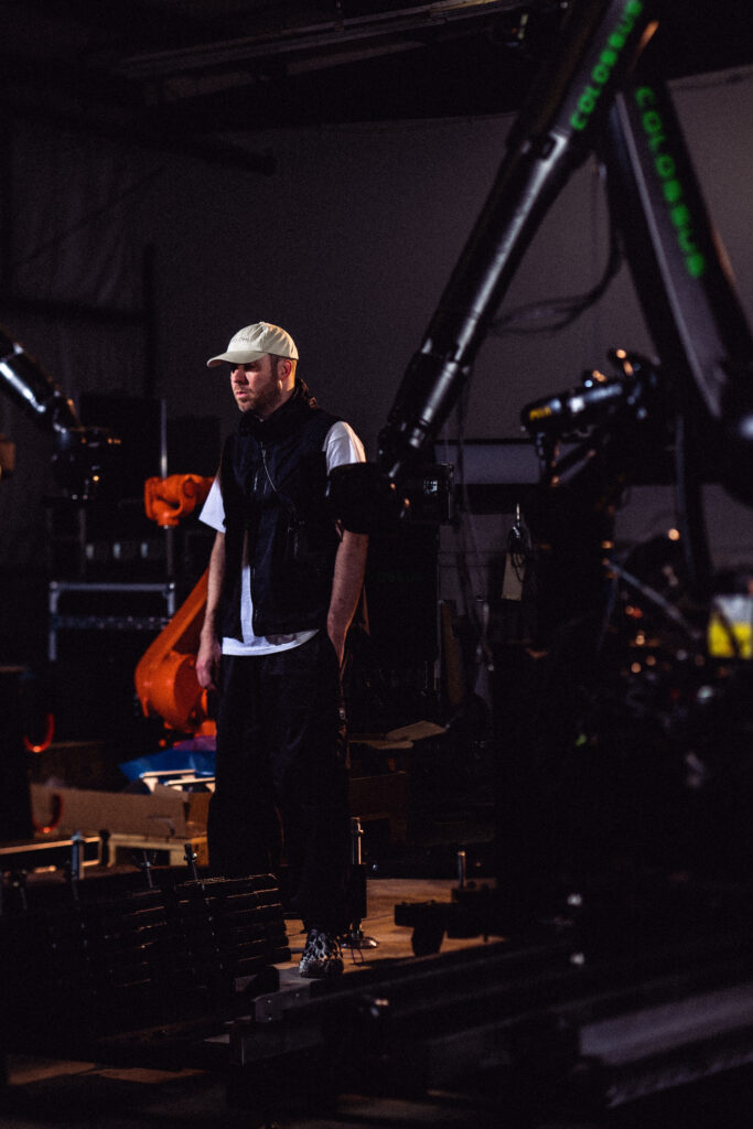 press photo of artist next to a machine