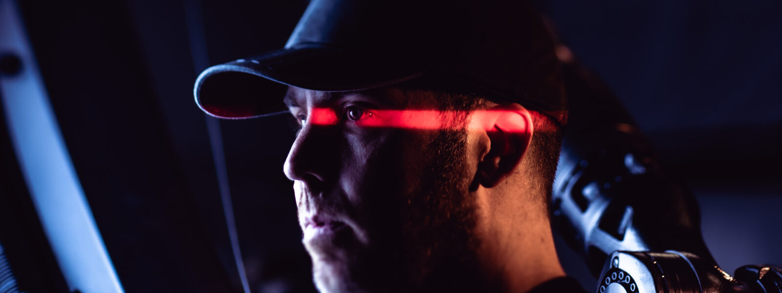 photo of man in a black hat with a red light across his face