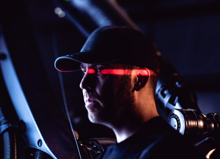 photo of man in a black hat with a red light across his face