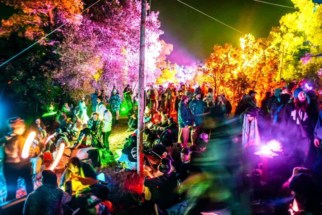 An illuminated crowd of people walking around at a festival