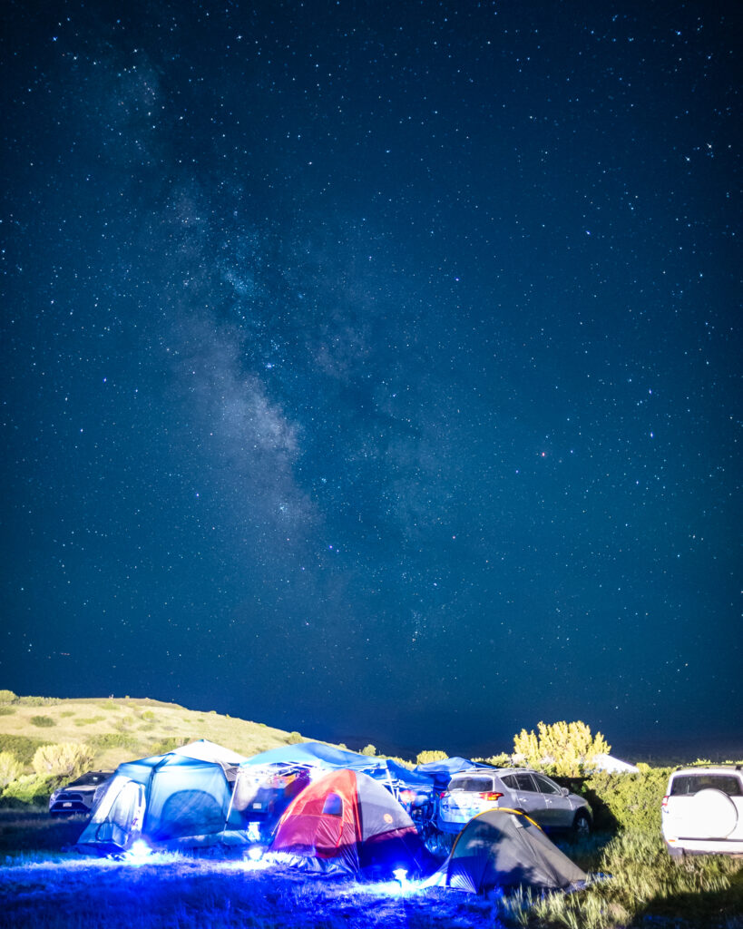 A lit nightsky over some tents.