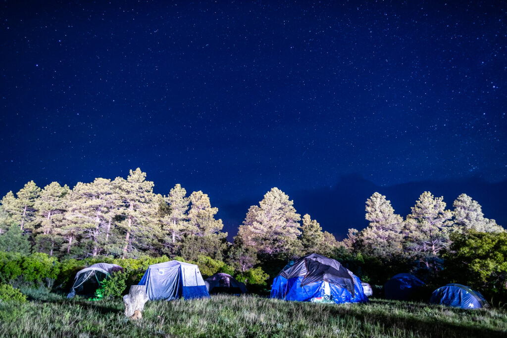 A lit nightsky over some tents.