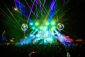 Photo of a festival stage with lasers.