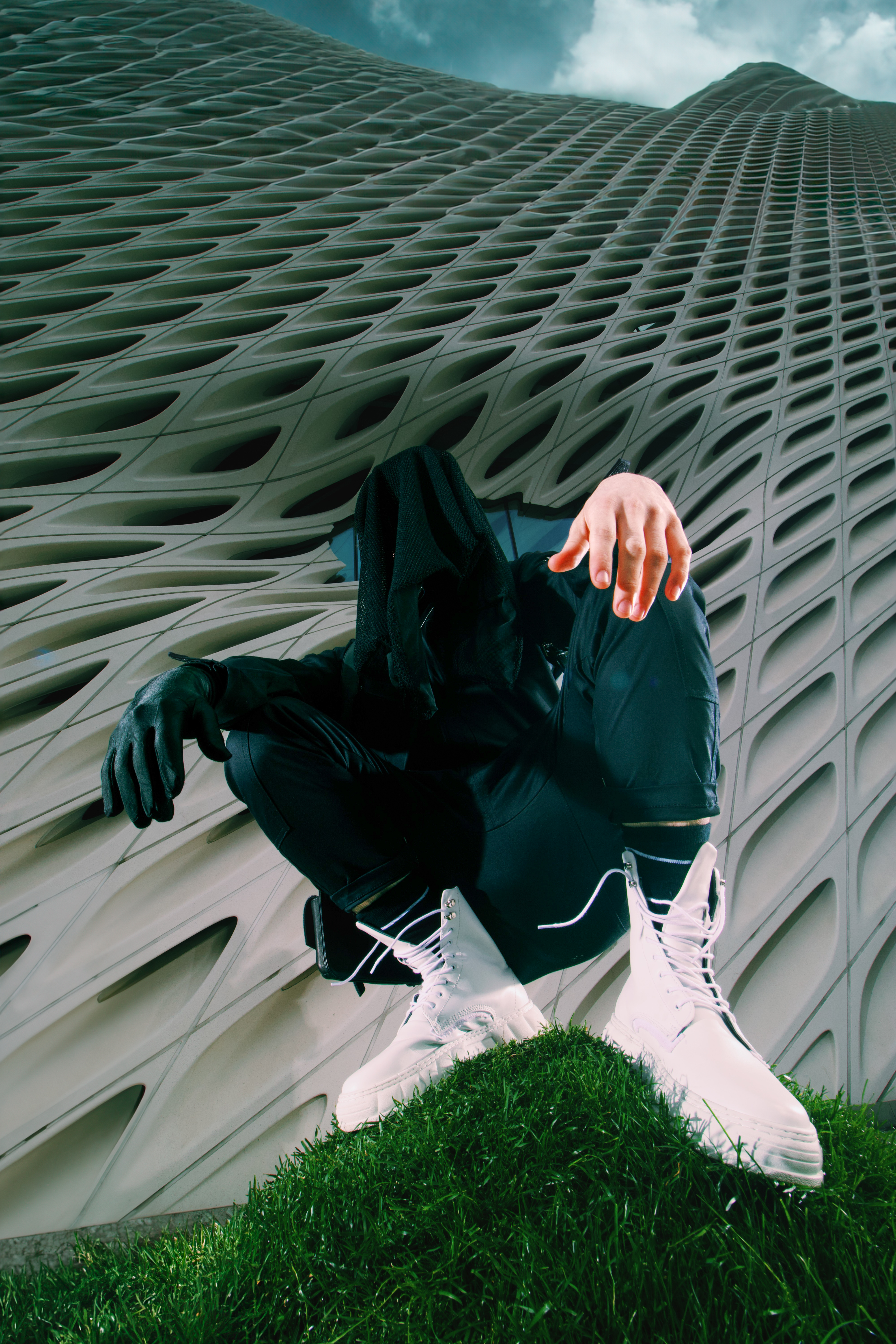 Modapit press photo: white shoes, black glove, standing on grass hill