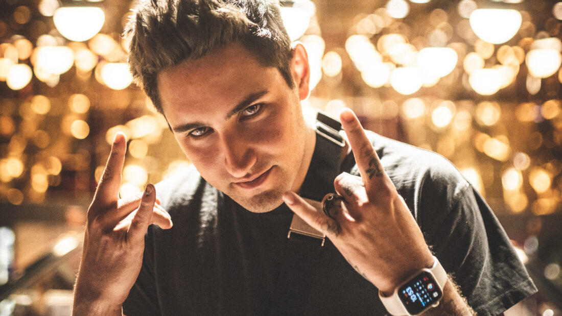 Jauz posing in front of bright natural LED lights hanging on the ceiling