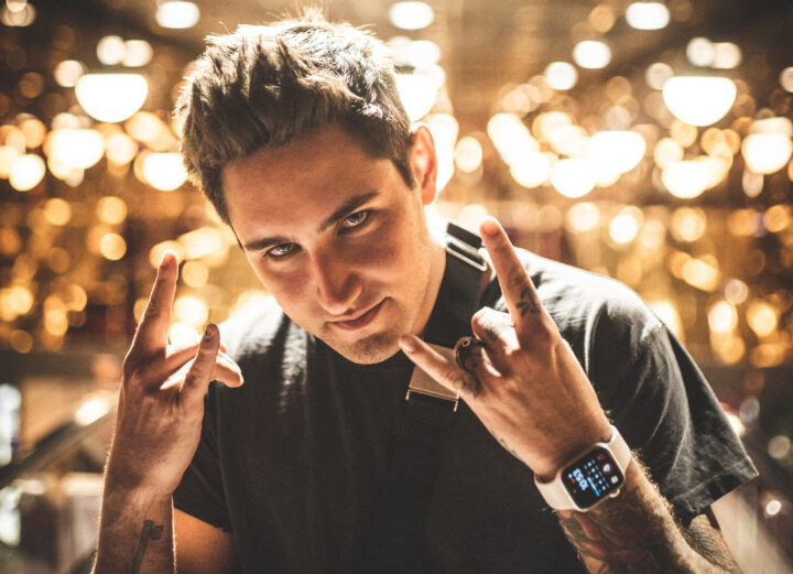 Jauz posing in front of bright natural LED lights hanging on the ceiling