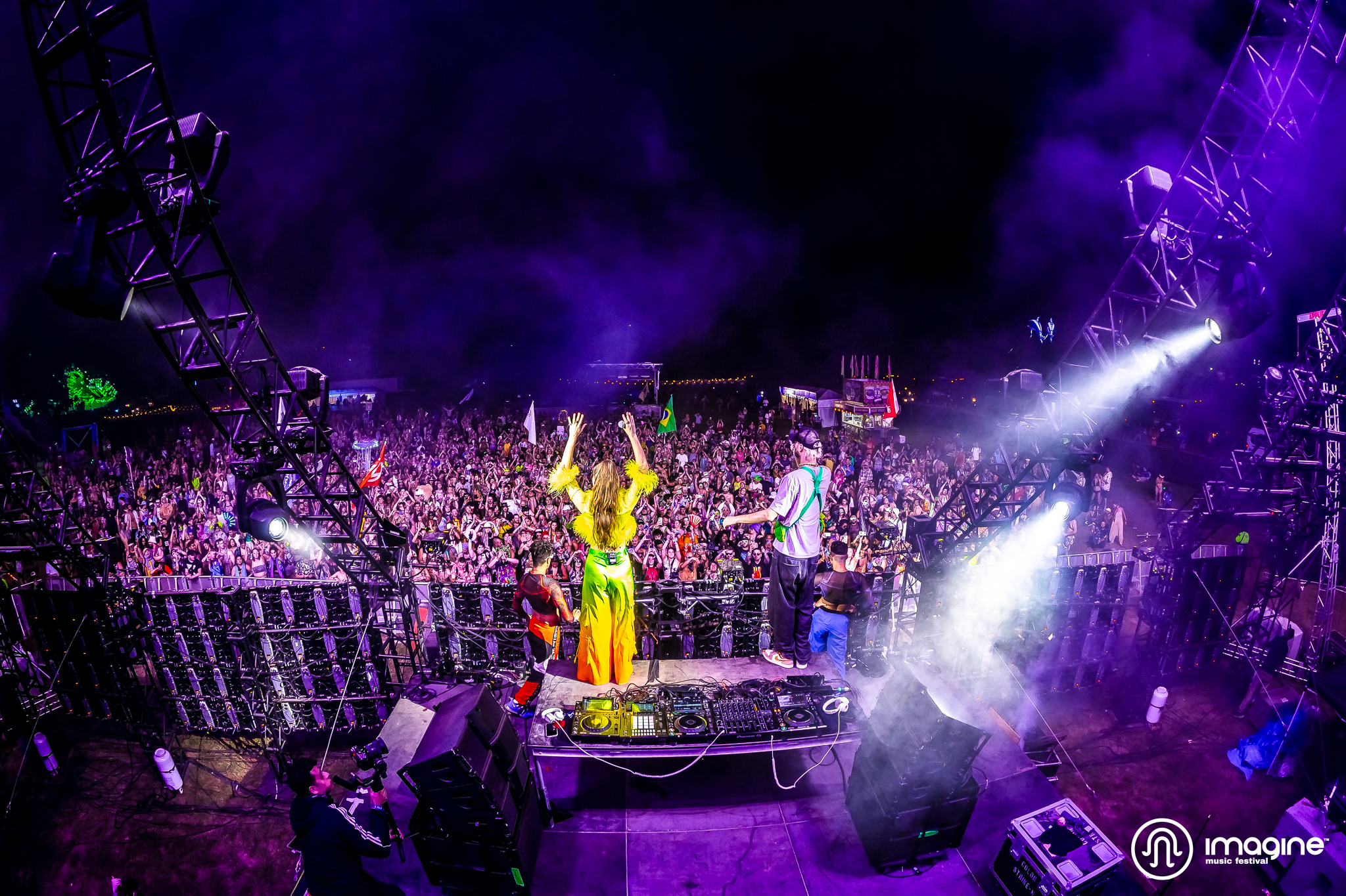 Sofi Tukker standing on stage dressed in colorful outfits, waving to the crowd