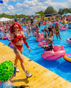 Girl in red two piece bathing suit walking by the pool at Imagine Music Festival 2023