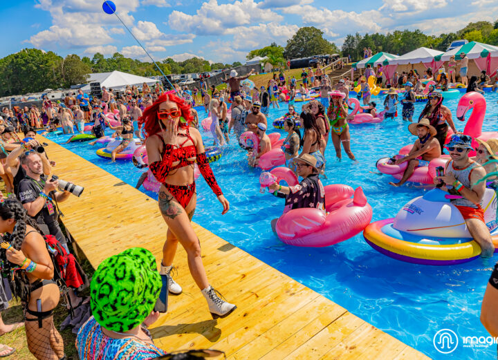 Girl in red two piece bathing suit walking by the pool at Imagine Music Festival 2023