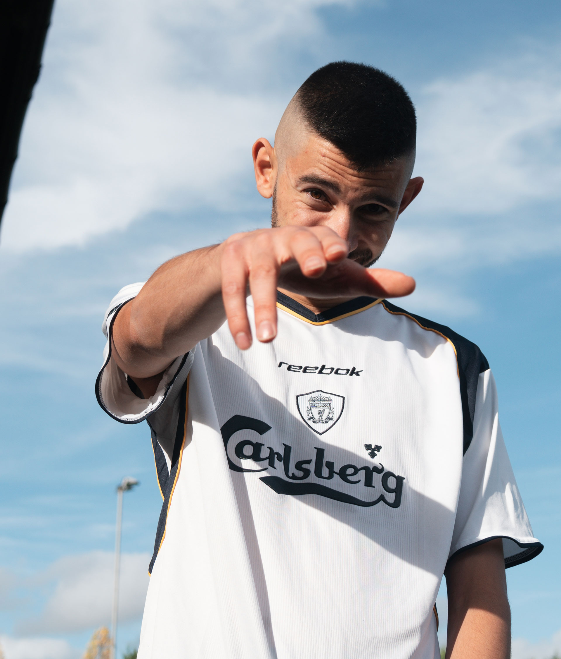 Hamid wearing a white football jersey for Carlsberg.