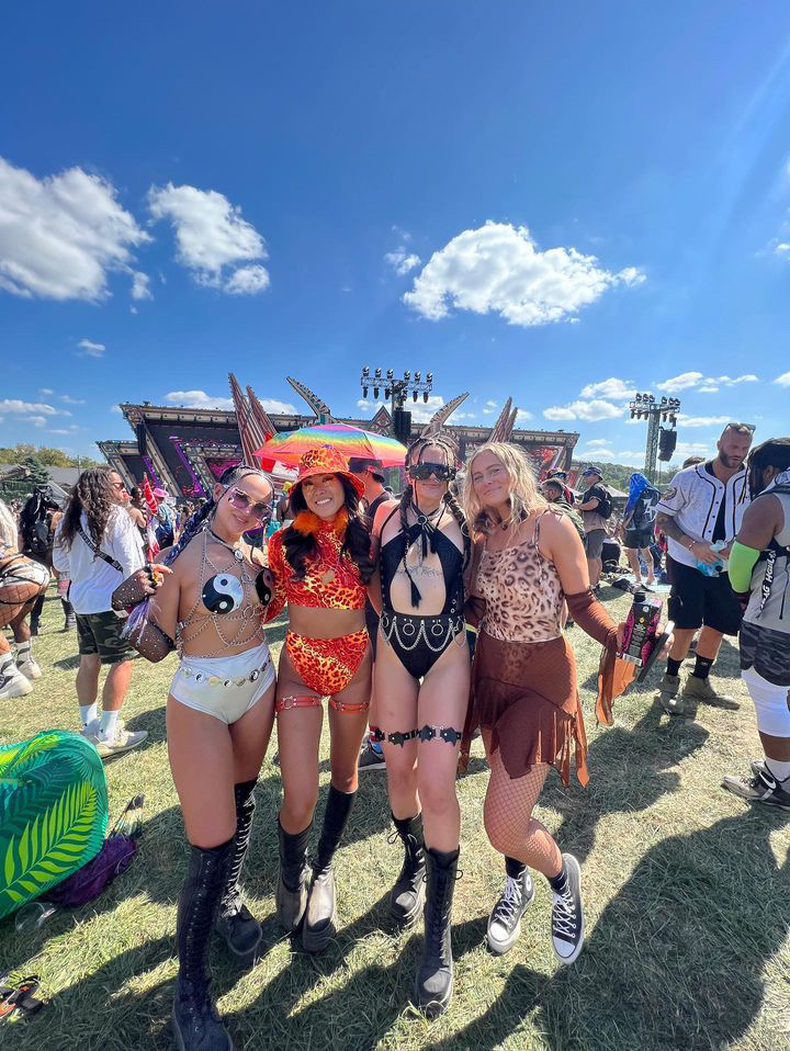 Group photo of four women wearing different festival fits of all different colors at Lost Lands 2023