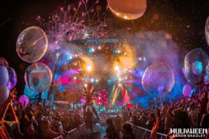 Hulaween main stage. Balloons flying around. Bright lights coming from the stage.