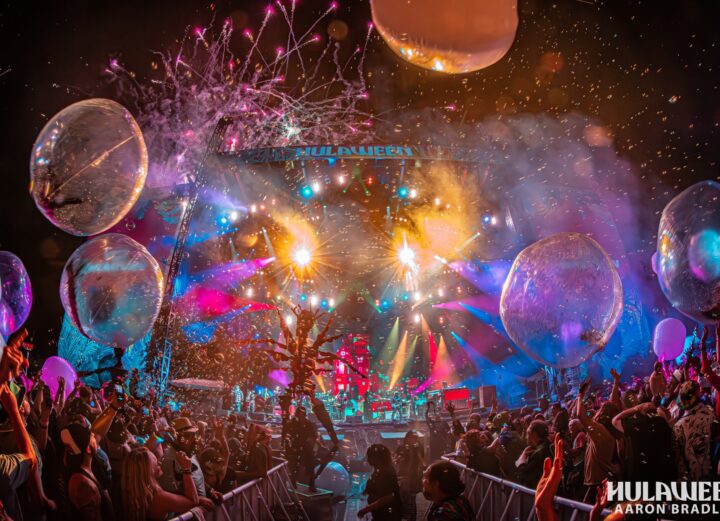 Hulaween main stage. Balloons flying around. Bright lights coming from the stage.