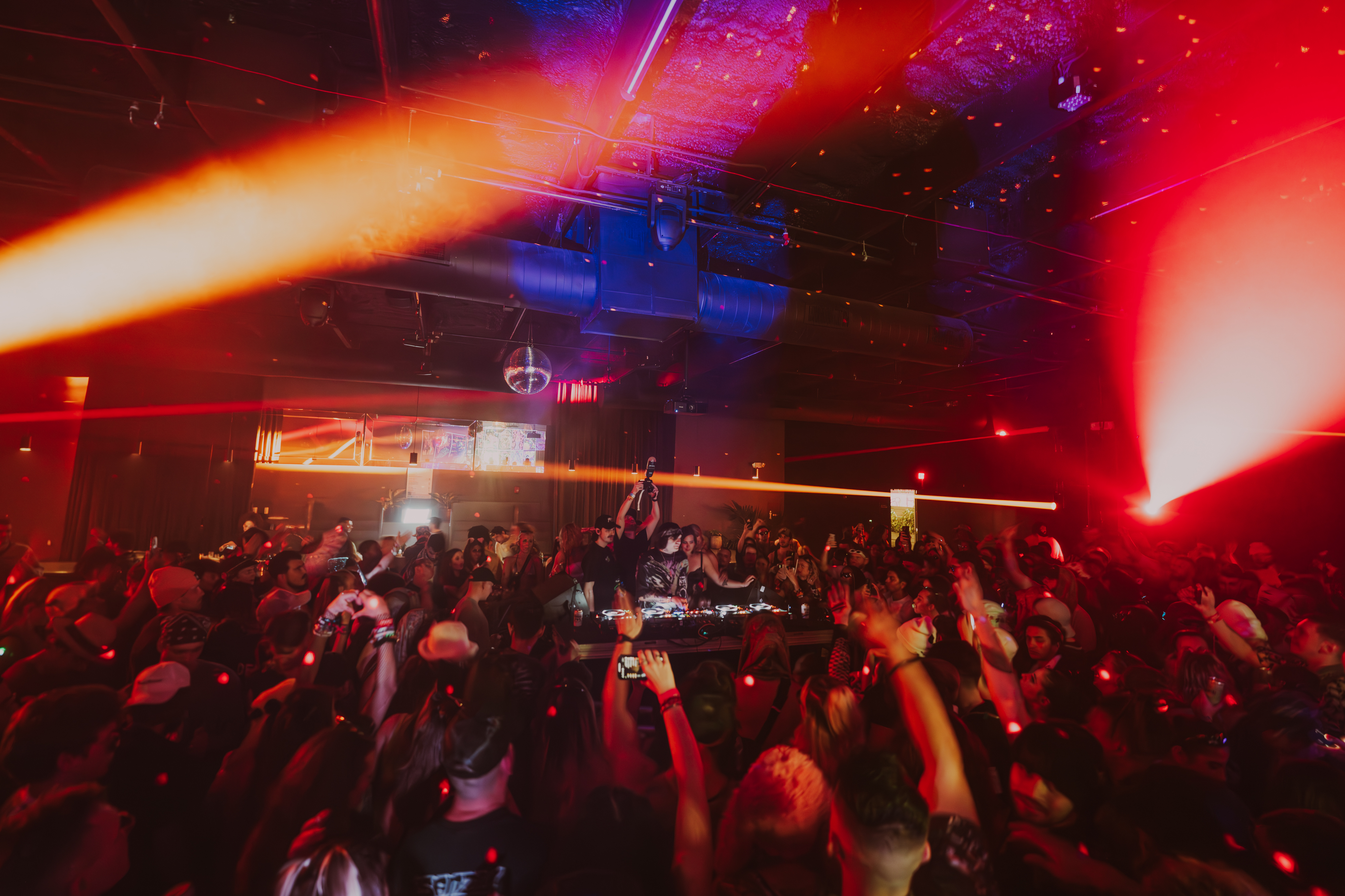 SVDDEN DEATH DJ playing in a warehouse in Miami with red lights.