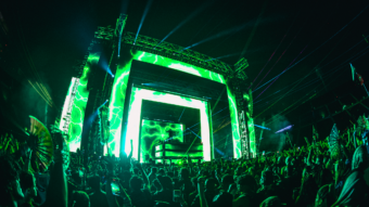 Photo of green illuminated festival stage at Shambhala in British Colombia