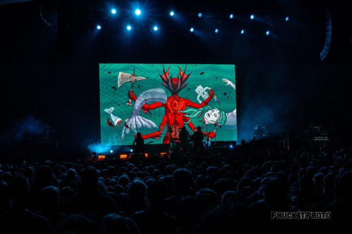 LED screen depicting a red anime character with four arms live at a concert.