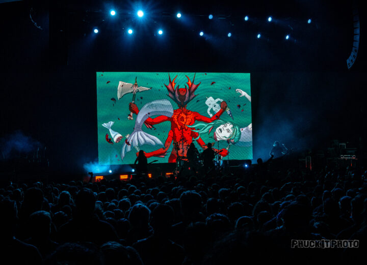 LED screen depicting a red anime character with four arms live at a concert.