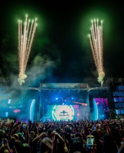 Global Dance Festival main stage with green fireworks shooting into the sky at night.