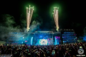 Global Dance Festival main stage with green fireworks shooting into the sky at night.