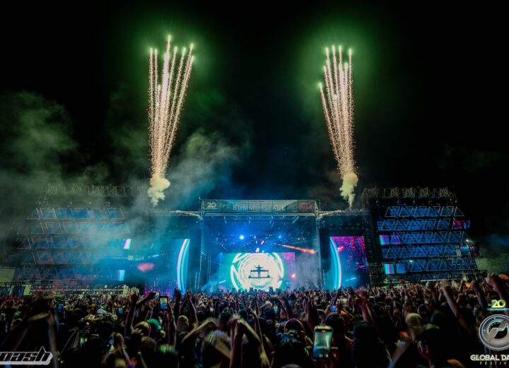 Global Dance Festival main stage with green fireworks shooting into the sky at night.