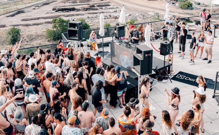 The Deep pool party featuring a crowd watching a DJ play a rooftop set in Denver